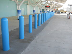 Row of bollards with light blue thermoplastic bollard covers.