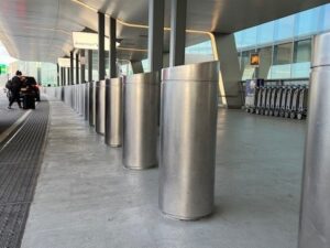 Stainless steel bollard covers over bollards at LaGuardia airport.