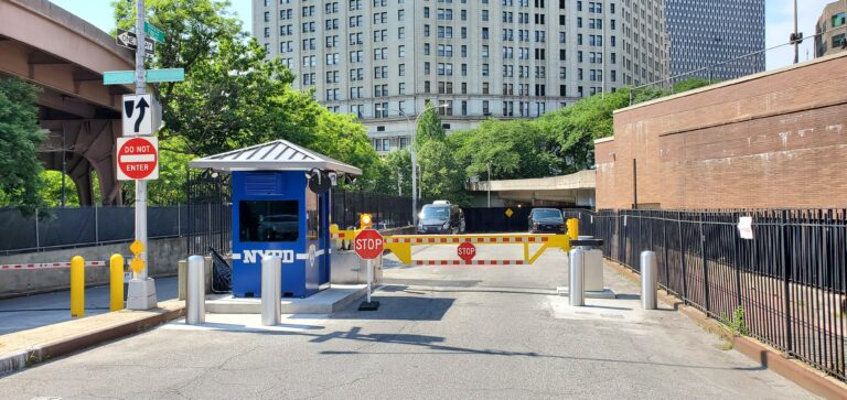 Active drop arm and passive fixed bollards at a secured vehicle entrance